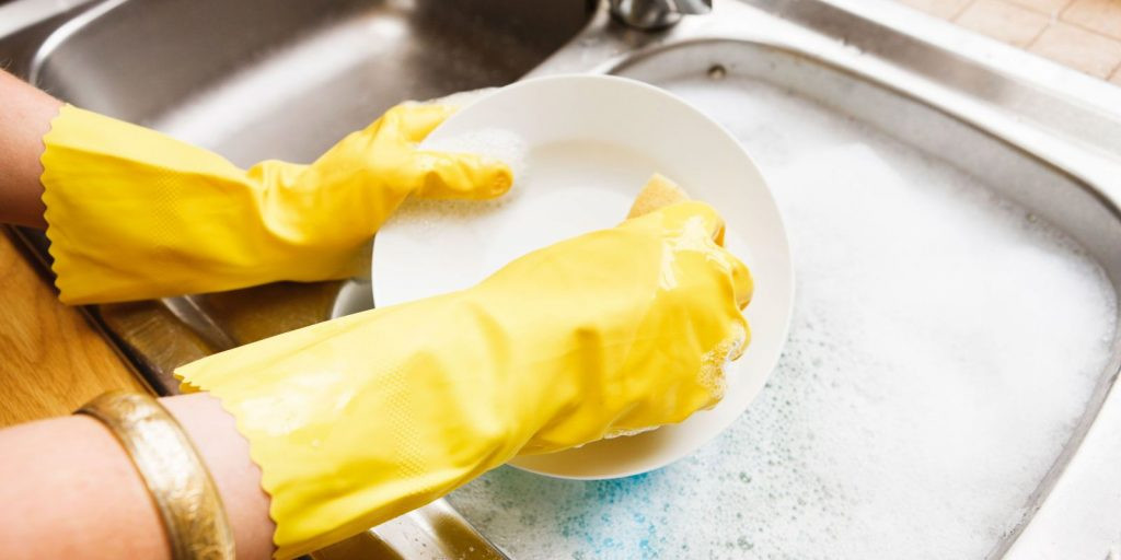 Người phụ nữ đeo găng tay bảo vệ khi làm việc nhà, phương pháp hiệu quả để phòng ngừa móng tay khô thiếu chất gì do hóa chất và tổn thương vật lý.