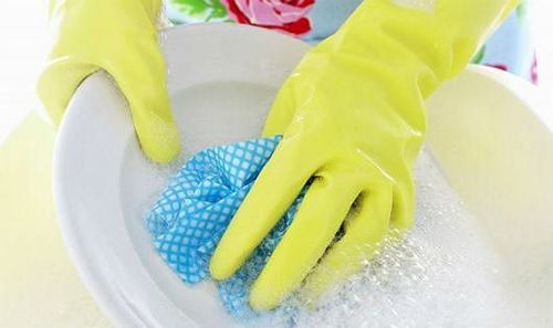 Người phụ nữ đeo găng tay cao su màu hồng khi làm việc nhà