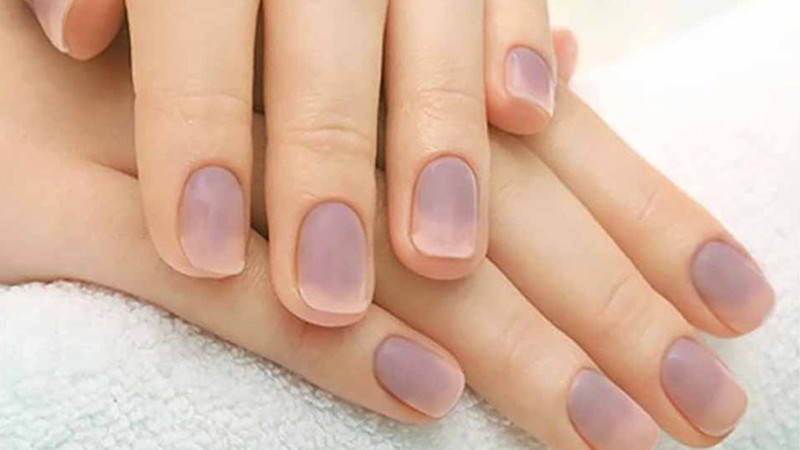 Người phụ nữ rửa chén bát với găng tay bảo vệ để tránh móng tay bị xanh và hư hại