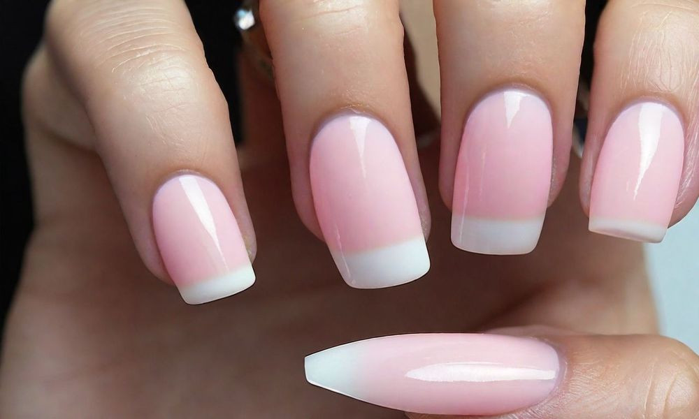 Người thợ đang sơn lớp gel lỏng lên móng tay khách hàng, sau đó sẽ được làm cứng dưới đèn UV/LED, minh họa quy trình làm móng gel và nguy cơ dị ứng sơn móng tay.