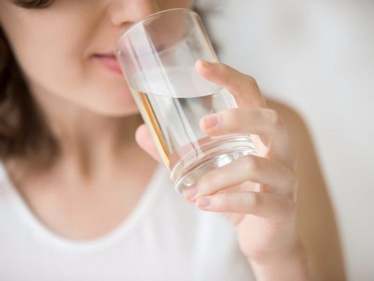 Phụ nữ đang uống nước khoáng từ chai