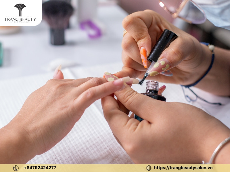 Sơn lớp base coat mỏng đều lên móng tay trong quy trình tự sơn móng tay gel tại nhà