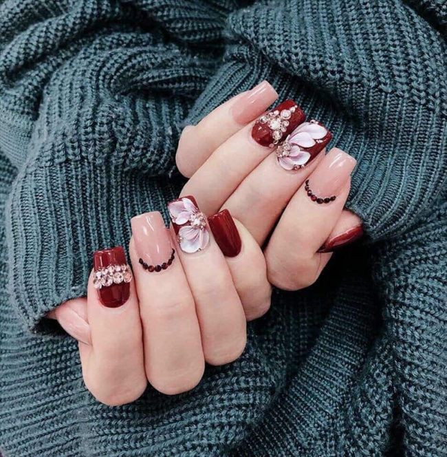 Sơn Móng Tay Màu Đỏ Mận: Nét Quyến Rũ Bất Tận Cho Phái Đẹp Sơn móng tay màu đỏ mận với họa tiết hoa nổi 3D tinh xảo, tăng vẻ nữ tính