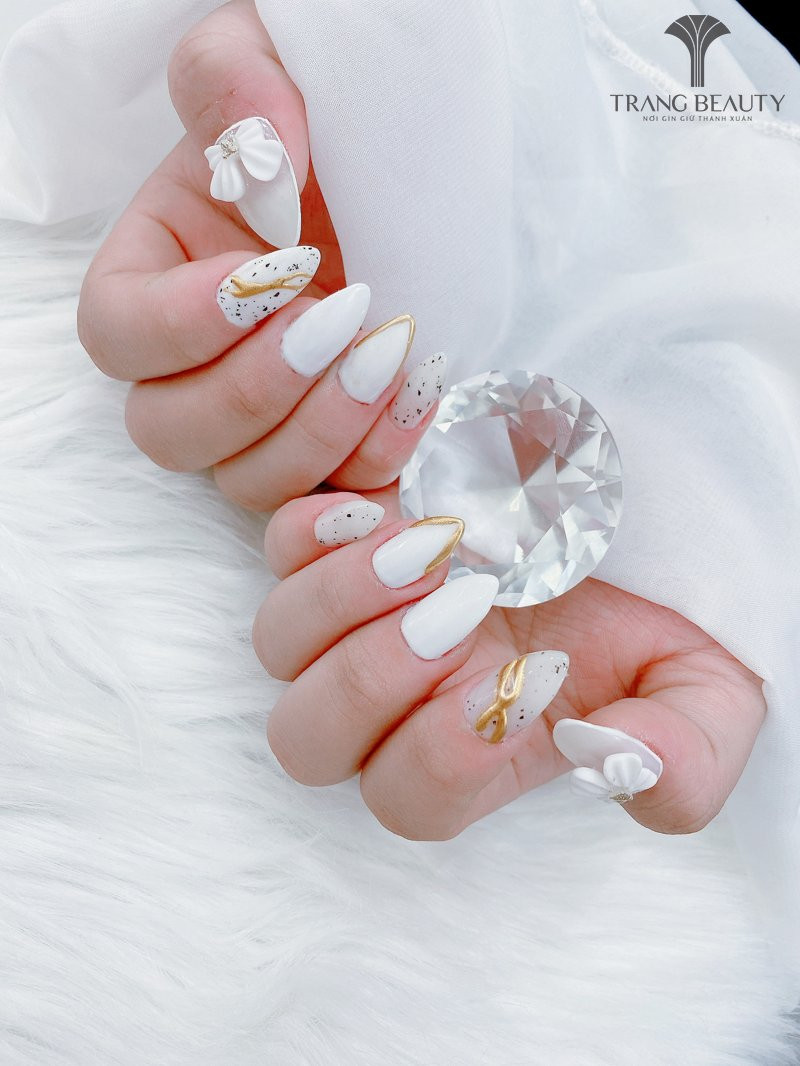 Sơn móng tay màu gạo trong với họa tiết nhũ vàng độc đáo