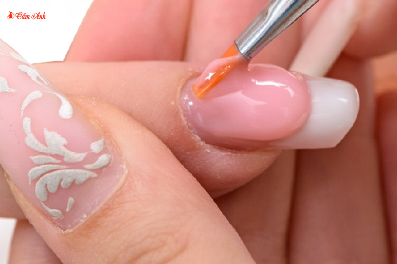 Thợ nail đang tỉ mỉ đắp bột lên móng tay