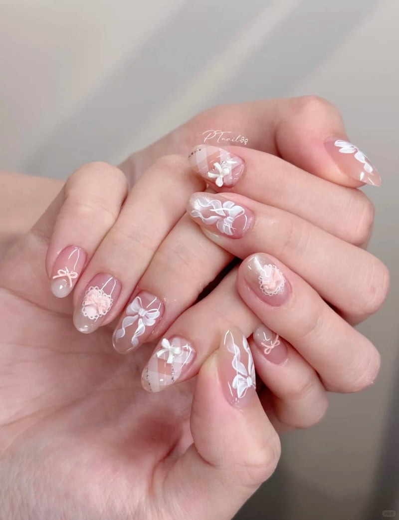 Vẽ móng tay đơn giản kết hợp đính charm nơ nhỏ màu trắng trên nền hồng