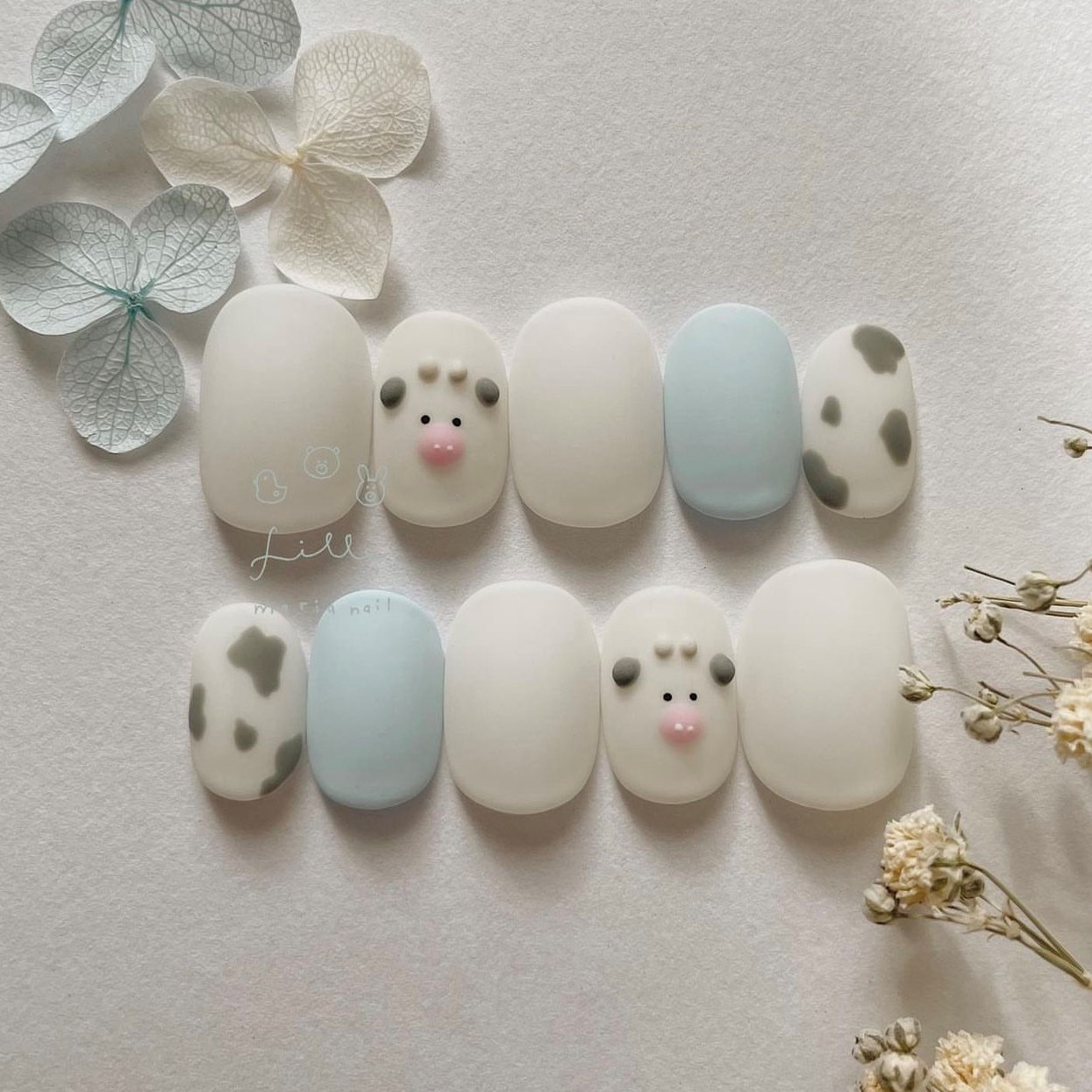 Vẽ móng tay hình chú bò sữa với đốm đen trắng trên nền hồng
